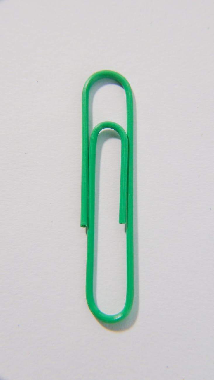 a close up shot of a green paper clip